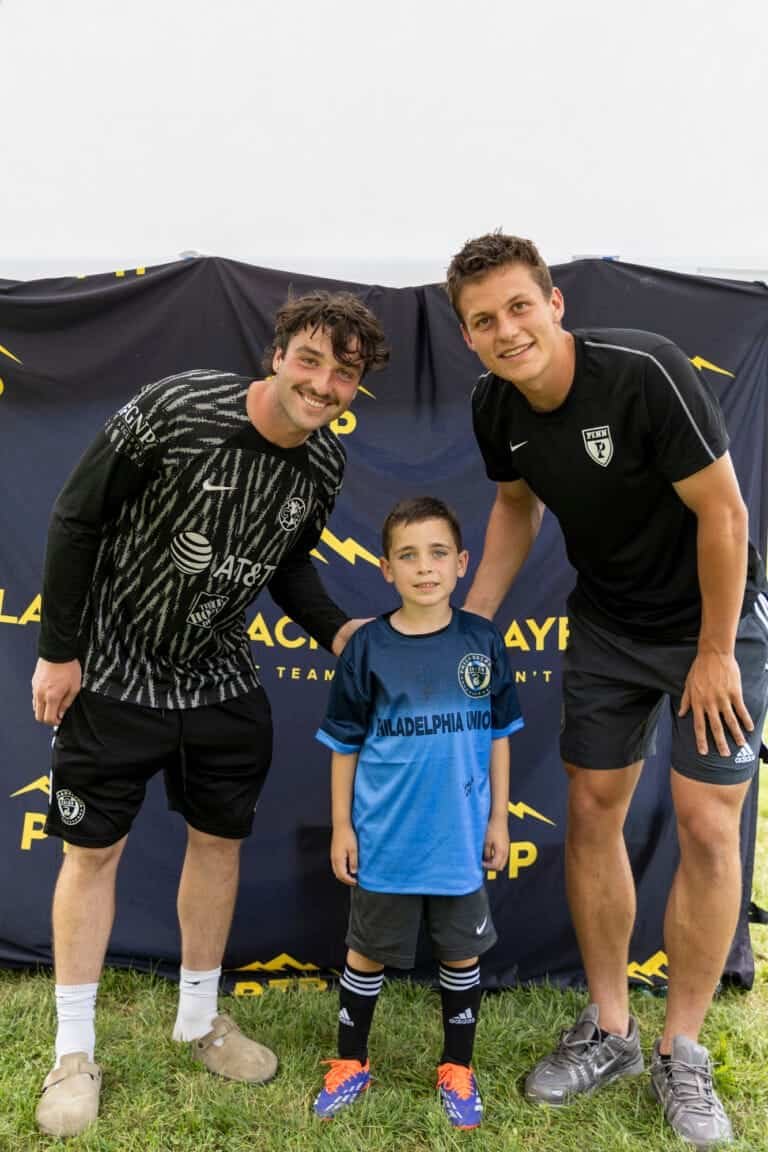 PTP Pros pose for a picture behind PTP banner at 2025 summer camp in Wayne, PA