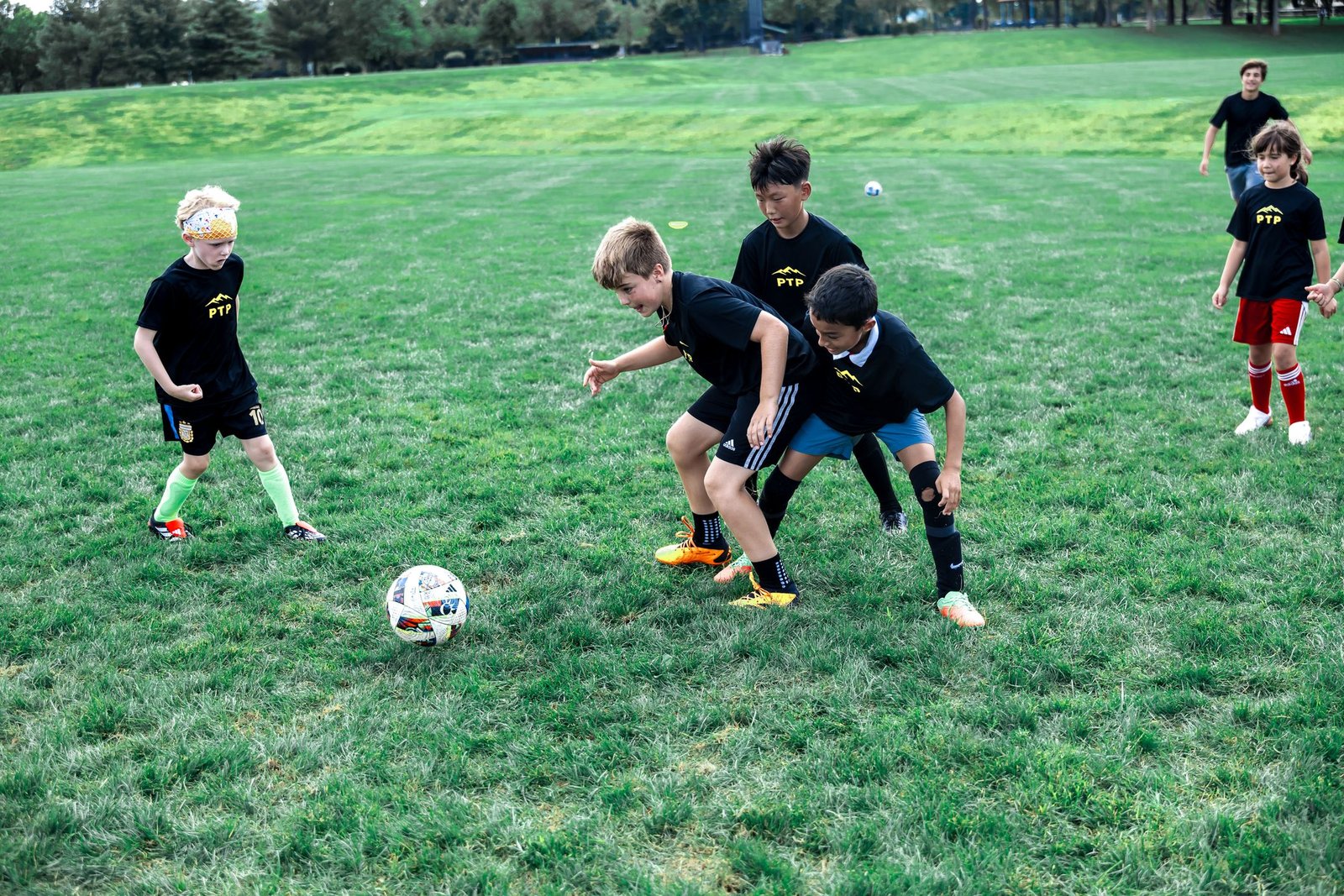 Camper dribbles past a coach with other players nearby